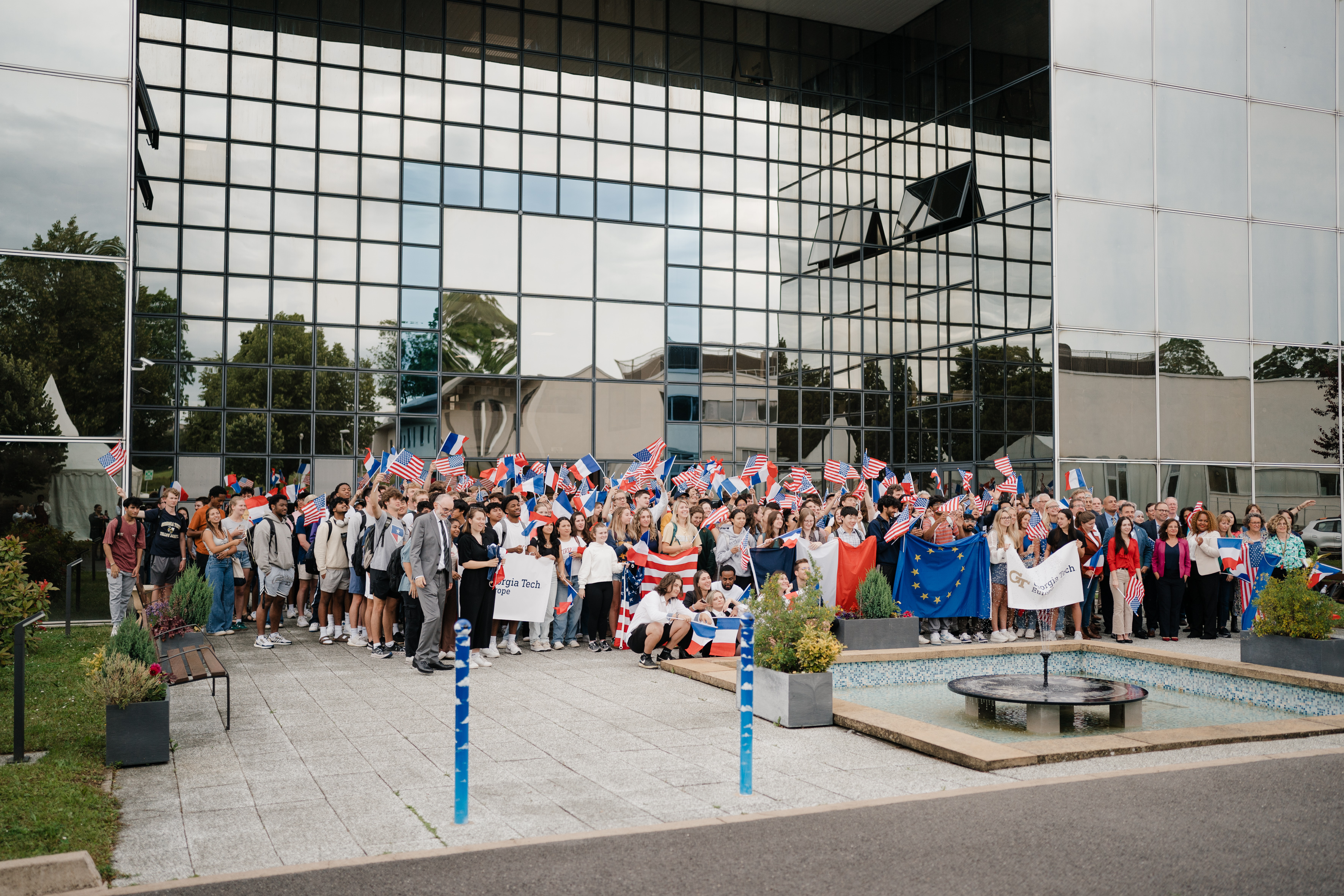 Group shot of students and faculty and board member in front of GTE building