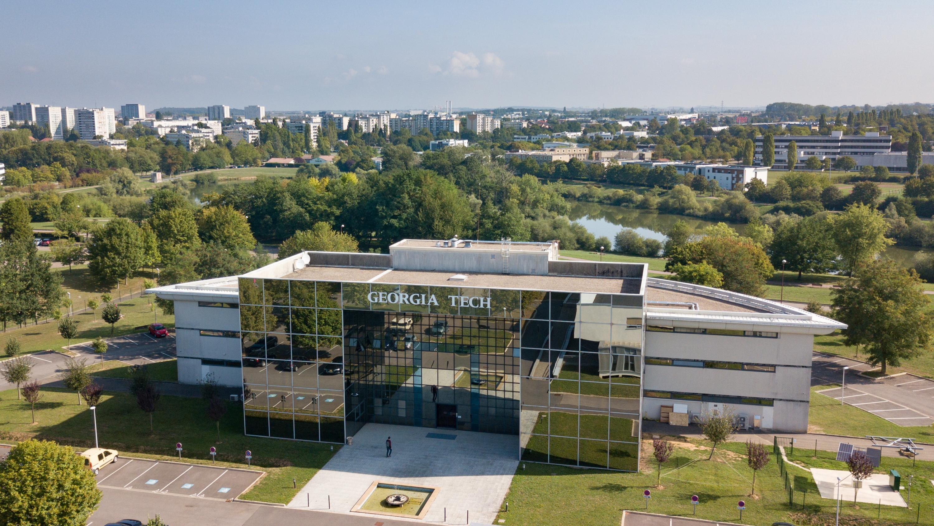 Large glass building with a student in front